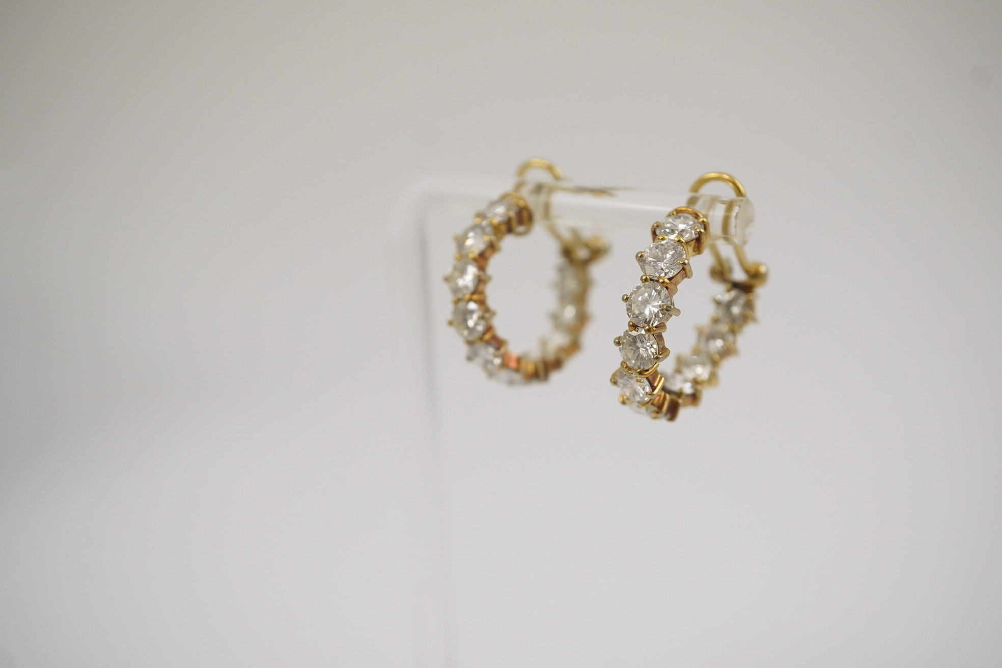 A modern pair of 18ct gold and graduated eleven stone round brilliant cut diamond set hoop earrings